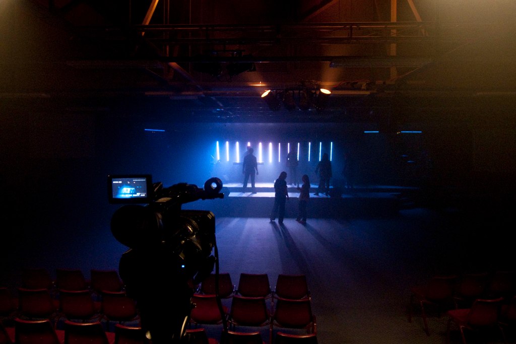 vertical LED strip lights on a stage in an empty room
